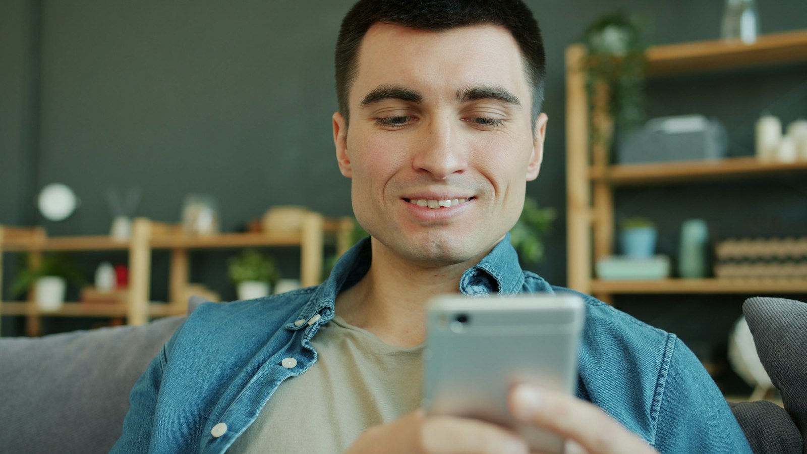 A person smiling while reading a message on their phone